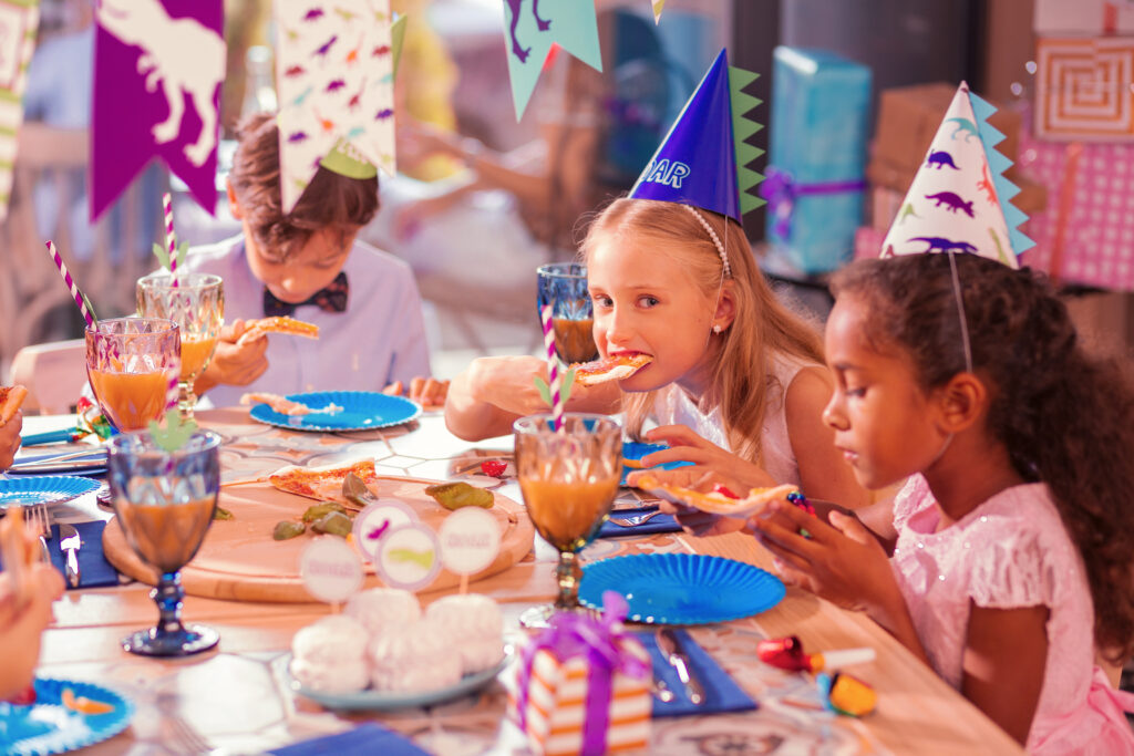 Three children sitting silently while eating tasty food
